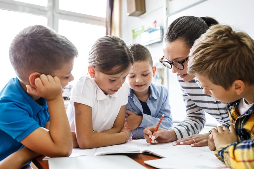 Building Resilience: Teaching Children to Overcome Challenges 2 Student thoughtfully completing a challenging assignment, guided by a teacher — building resilience through learning.
